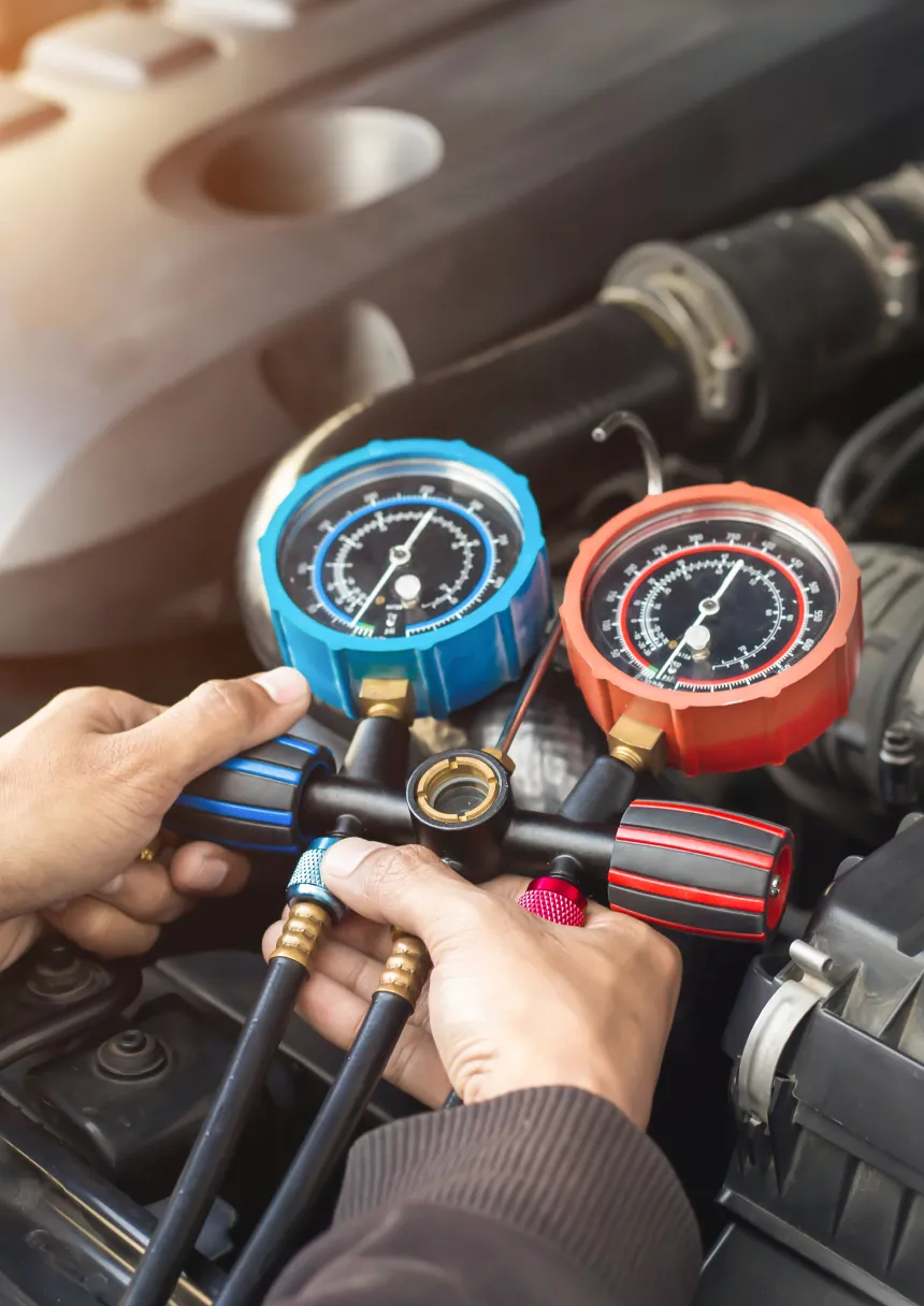 Man checking car air conditioning gauges