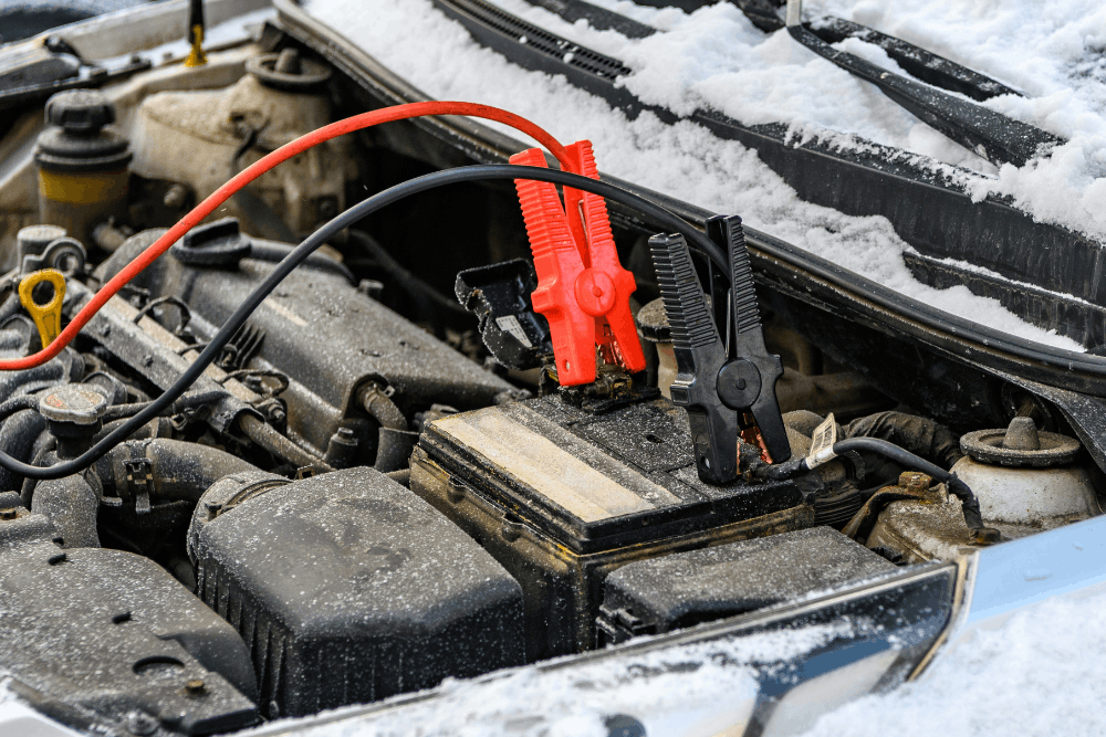 Car battery problems, auto repair in Smyrna, DE by Pristine Motorsports.Image of jumper cables connected to a vehicle battery in cold weather to restore power and ensure reliable starting.